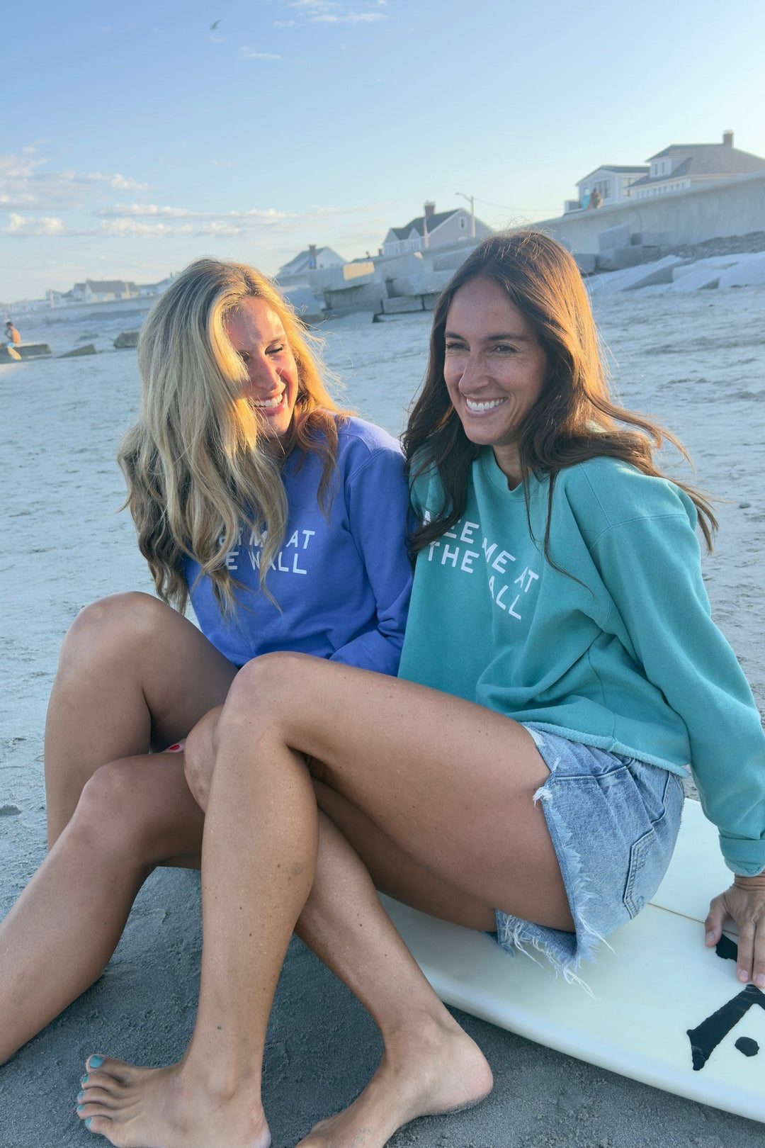 Meet Me At The Wall seafoam sweatshirt on model laughing with friend at the beach