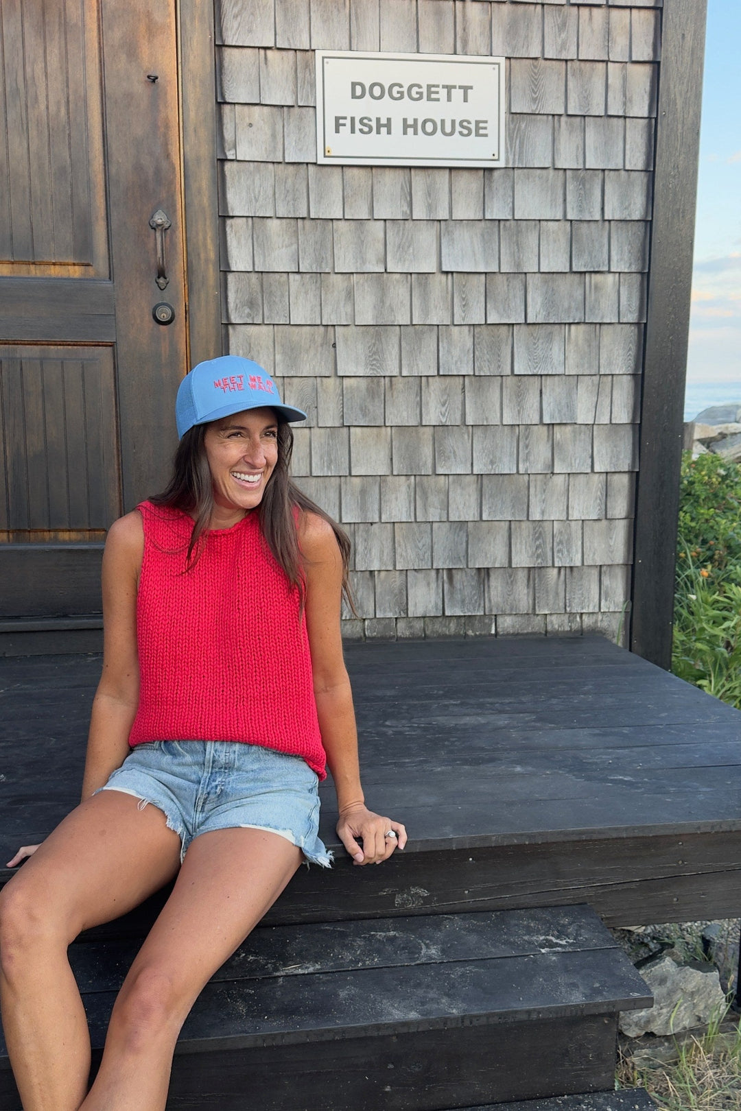 Meet Me At The Wall light blue trucker hat on model at Doggett Fish House