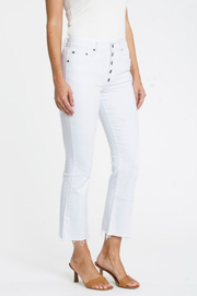 White cropped flare jeans with raw hem and visible button closure